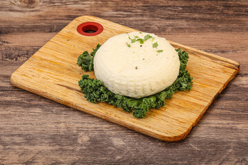 Caucasian suluguni round cheese piece