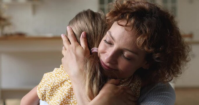 New caring loving mother for orphan kid girl, Happy motherhood and Mother Day celebration concept. Young woman embracing little daughter feeling unconditional love gives protection and care, close up