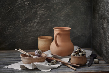 Still life in a rustic style. Quail eggs and set of ceramic dishes on a wooden table.