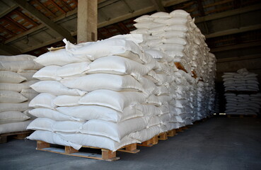 Large sacks of grain are stacked in the warehouse.