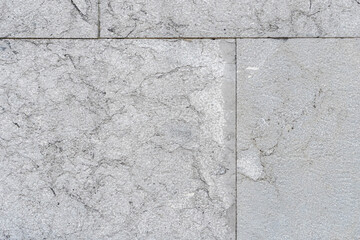 Cracked gray wall tiles. Cracks and seams close up. Geometric shapes