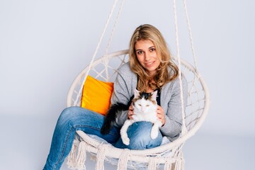 Frau in Schaukelsessel mit Katze Kater weißer Hintergrund, copy space, gemütlich Zuhause,...