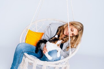 Frau in Schaukelsessel mit Katze Kater weißer Hintergrund, copy space, gemütlich Zuhause,...
