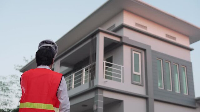 The engineer looking new house design of a modern style. Contractor recheck around of final house building and passed to the customer. Concept of building a house with confidence.