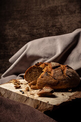 Bread and drying lie on a wooden board on a dark background
