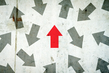 Arrows in different directions on a concrete wall. Red arrow, right direction. Leadership concept....