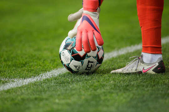 Details with a soccer goalkeeper grabbing a Select ball during a game.