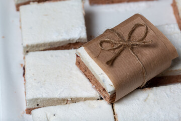 Portion marshmallow with cocoa and cranberries. Wrapped in paper and tied with string. Two-layer zephyr.