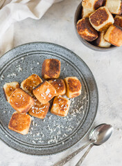 Square curd pancakes, traditional Russian cheese cakes in a gray plate and bowl, with coconut flakes. View from above. Menu concept