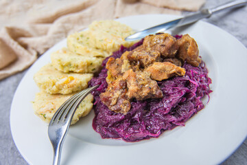 Roast pork with dumplings and sauerkraut. Typical Czech national meal with homemade bread dumplings red cabbage on concrete texture background.