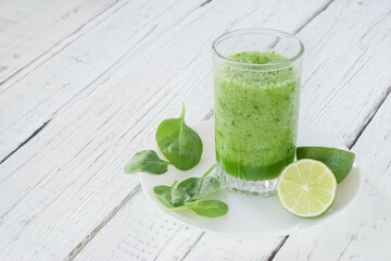 Empty space for text. Healthy lifestyle. Celery, spinach and lime smoothie. Drink glass, lime, spinach leaves.