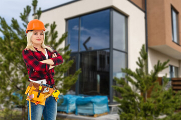 Happy woman on the background of a new house. Portrait of first time buyer, house owner, apartment renter, flat tenant or landlady. Moving day and buying own property concept