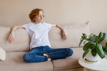 Empty space for text. A teenager is resting sitting on the couch.