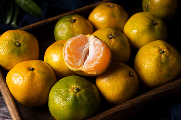 peeled and whole tangerines on old wooden table
