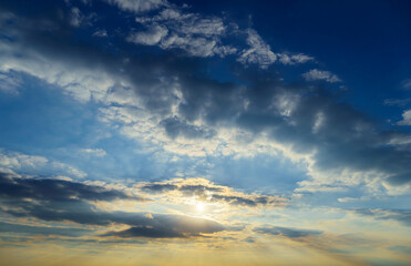 Obraz premium beautiful sunset sky, bright sun and dark silhouette of clouds as a background