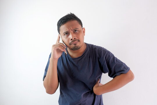 impatient man talking on phone with hand on the waist