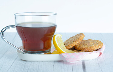 Cup of tea accompanied by a lemon slice and oatmeal cookies, healthy and natural foods.concept: vegan food