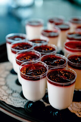 creamy dessert with berries in a plastic cup on a festive table