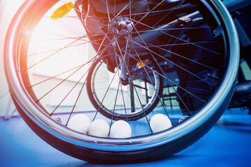 Disabled man in a wheelchair play at table tennis. Tennis balls fixed in a wheel