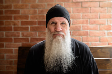 Portrait of mature man with long gray beard - 428554977