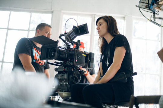 Female director of photography with a camera on a movie set. Professional videographer on the set of a movie