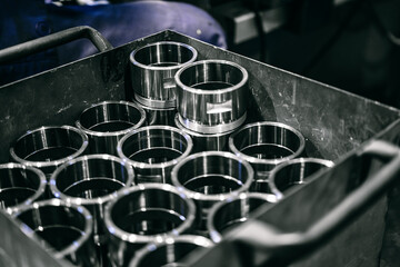 Shiny steel parts after cnc turning. Finished parts are in a metal box