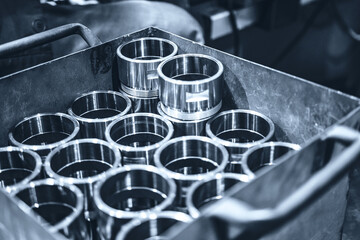 Shiny steel parts after cnc turning. Finished parts are in a metal box