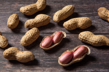 Obraz premium Raw fresh peanuts on wood background