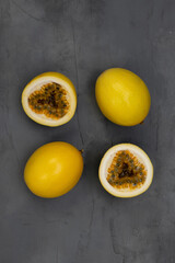 Yellow passion fruits on dark gray background. Top view