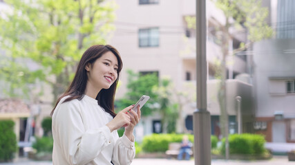 街でスマホを使う女性