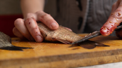 Obraz premium cleaning cutting fresh fish with a knife closeup