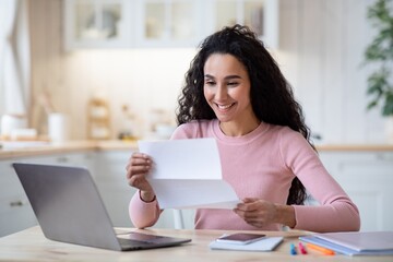 Portrait Of Excited Happy Woman Reading Letter In Kitchen