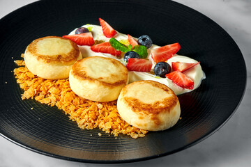 An ideal breakfast - Cottage cheese pancakes with white sauce, berries, strawberries and crunch in...