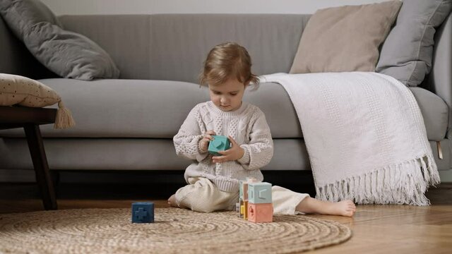 Litle cute child enjoy and concentrate playing colored  blocks, Slow Motion. Learning through play is an important part of a child&rsquo;s development. Child Development Concept.
