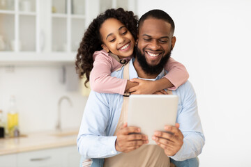 Happy African American family using tablet in the kitchen