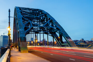 Fototapeta na wymiar Newcastle upon Tyne UK: 16th March 2021: Tyne Bridge long exposure with blurred traffic light trails during rush hour and blue hour