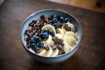 oatmeal bowl with fresh banana and blueberries and chocolate chunks