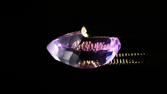 natural ametrine in the tweezers on the background