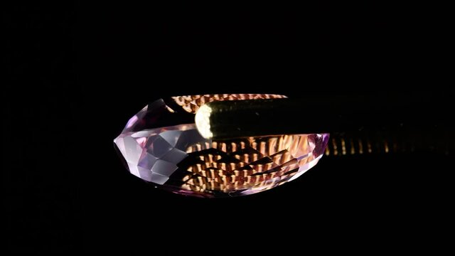 natural ametrine in the tweezers on the background
