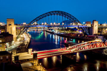 Obraz na płótnie Canvas Newcastle upon Tyne UK: 30th March 2021: Newcastle Gateshead Quayside at night, with of Tyne Bridge and city skyline, long exposure during blue hour