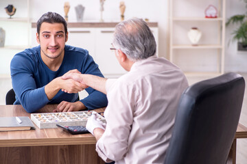 Obraz premium Young man visiting old male jeweler