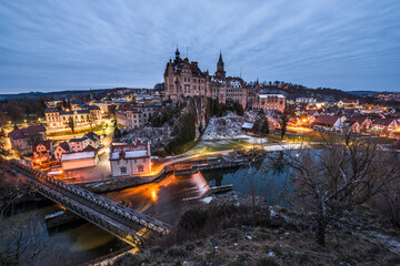 Zwielicht Aufnahme des Schloss Hohenzollern in Sigmaringen mit der Staustufe Wasserfall und Stausee im Hintergrund, Deutschland