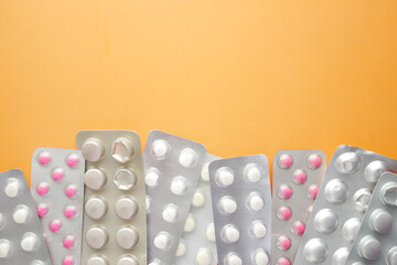 Close up of pills of blister pack orange background 