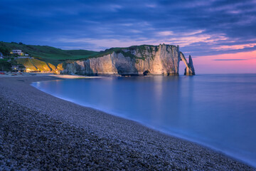 The chalk cliffs of Etretat after the sunset. Etretat, Normandy, France - obrazy, fototapety, plakaty