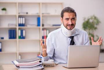 Young neck injured male employee working in the office