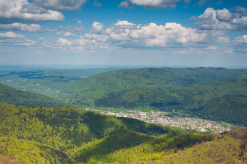 Fototapeta na wymiar panorama of mountainous terrain with a small town in the river valley