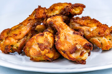 Fried chicken thighs on a white plate. The food in the restaurant. Food styling and restaurant meal serving.