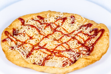 Langos stuffed with grated cheese and dressing.Langos is a traditional hungarian food. Food styling and restaurant meal serving.
