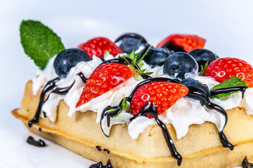 Waffles with whipped cream and fresh fruit. The food in the restaurant. Food styling and restaurant meal serving.
