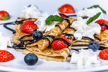 Pancakes with whipped cream and fresh fruit. The food in the restaurant. Food styling and restaurant meal serving.